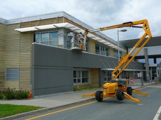 travaux de peinture sur les parements de bois Goodfellow de l'édifice des douanes canadiennes en Beauce