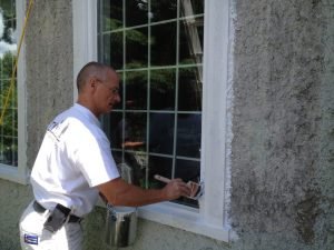 Peinture extérieure au pinceau sur fenêtre